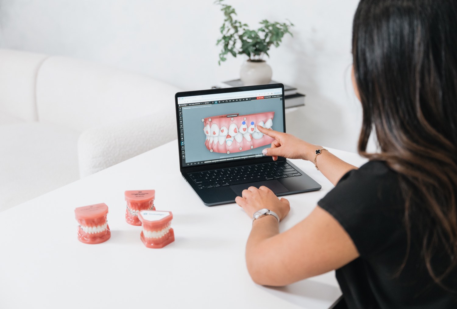 Dr. Lopez reviewing a digital orthodontic treatment plan on screen alongside physical study models