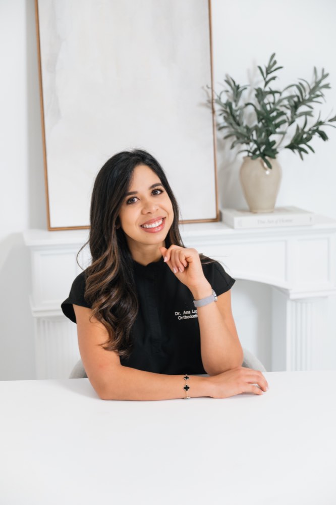 Dr. Ana Lilian Lopez seated at her desk at Lumiere Orthodontics